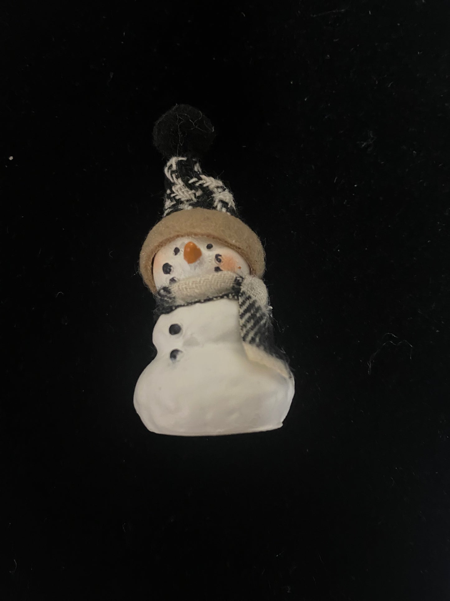 Small snowman figurine with a black background