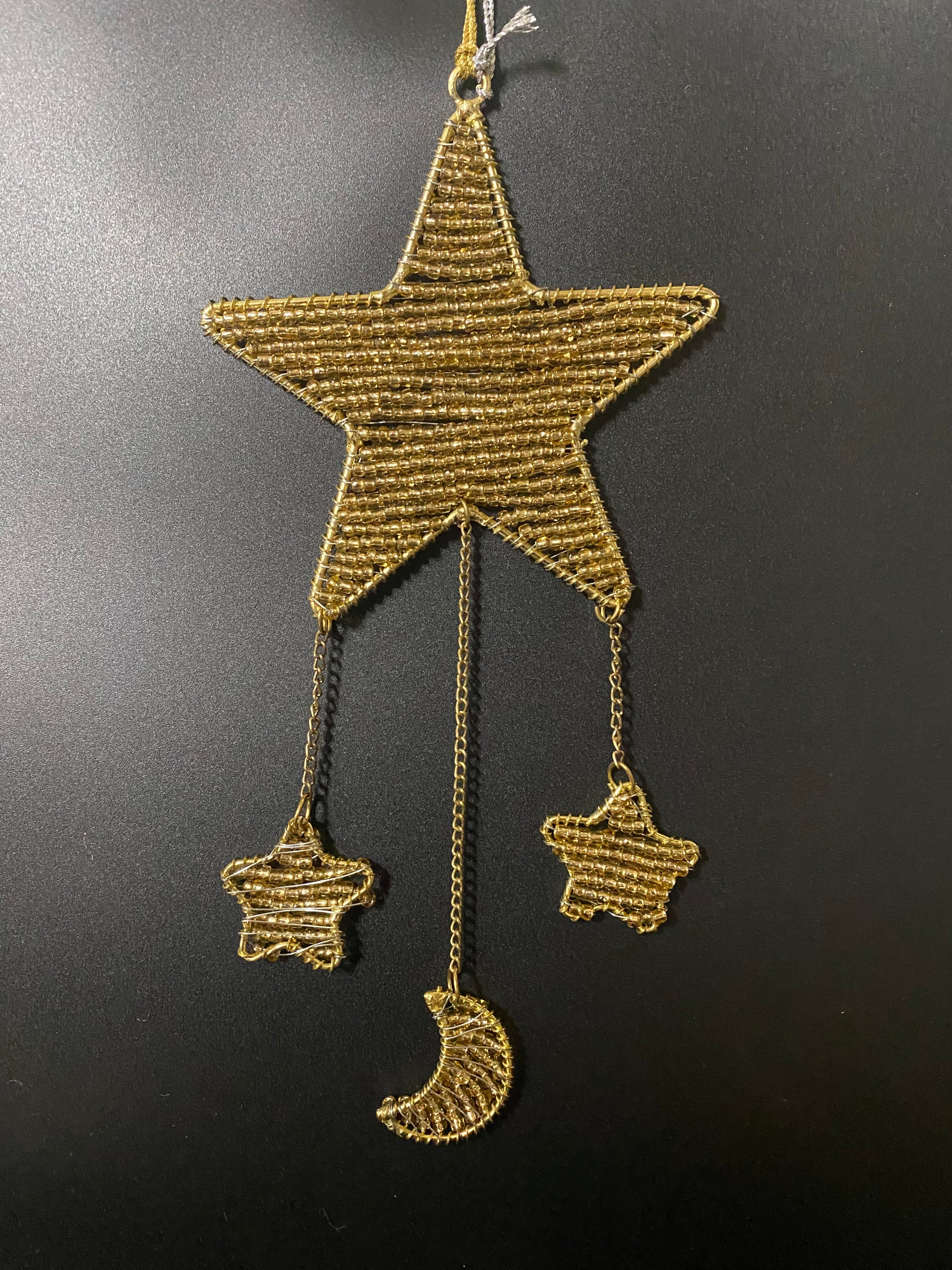 Gold star-shaped decorative item on a black background