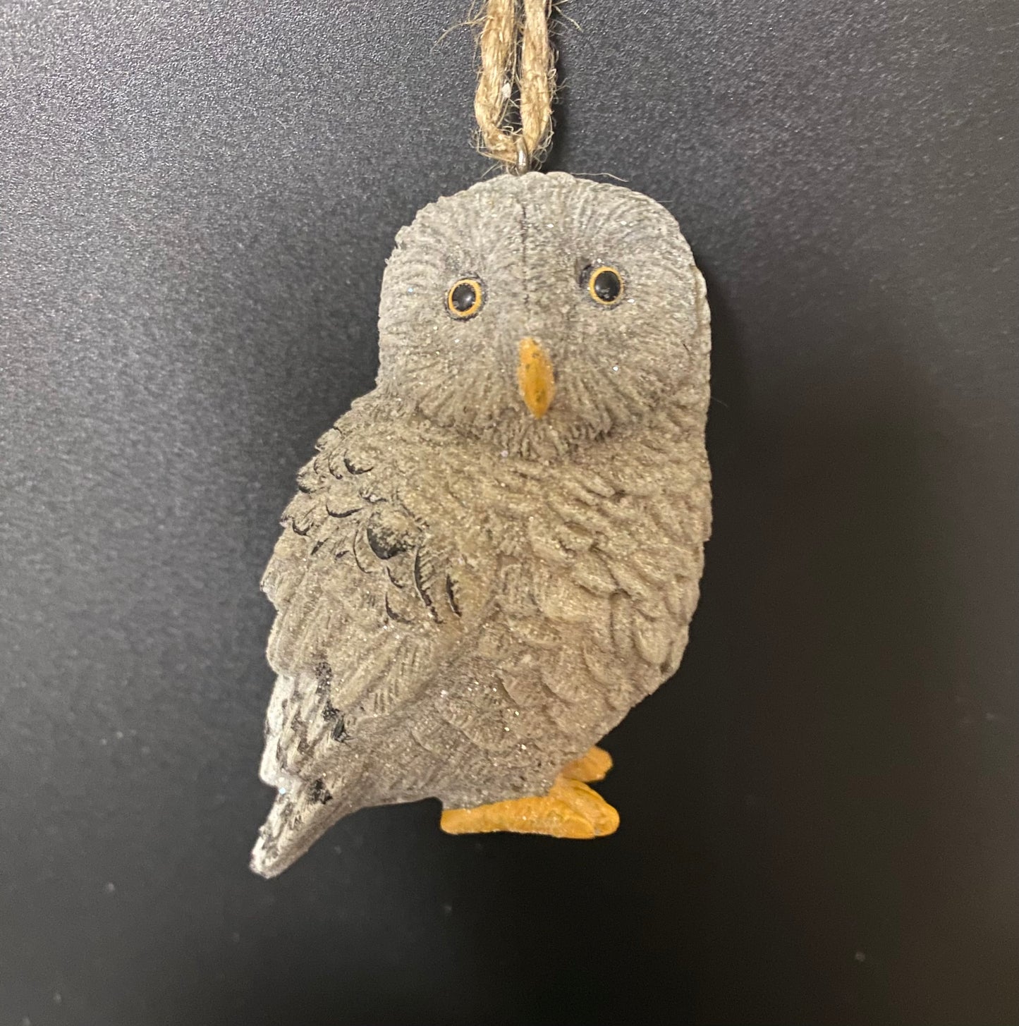 Decorative owl ornament hanging against a dark background
