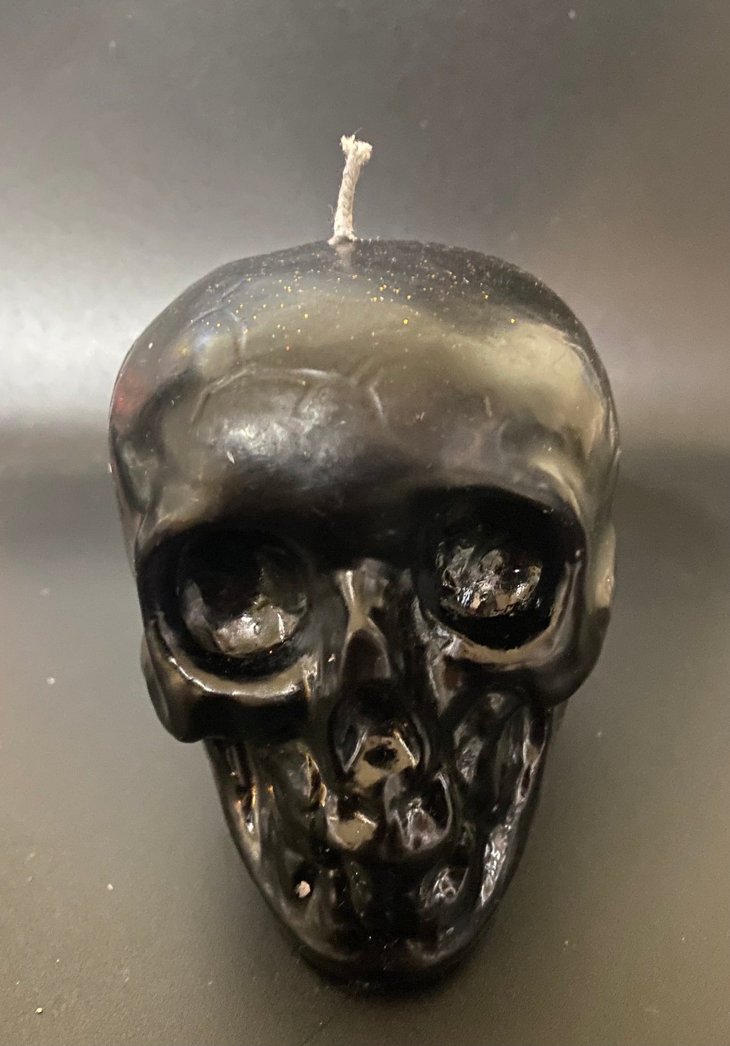 Skull shaped candle on a black background.