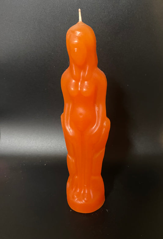 Orange candle shaped like a person on a black background