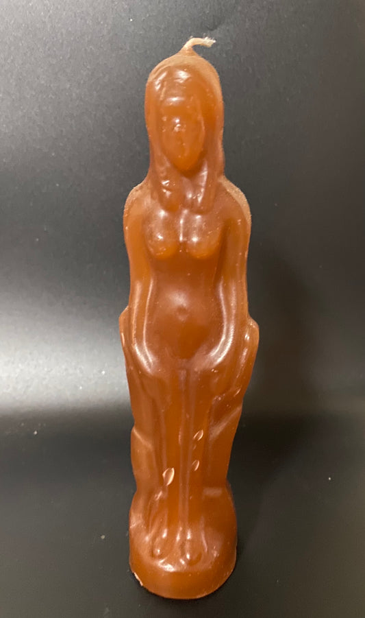 Brown candle shaped like a nude figure on a black background