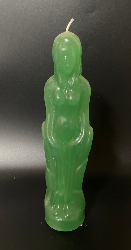 Green statue-shaped candle on a black background