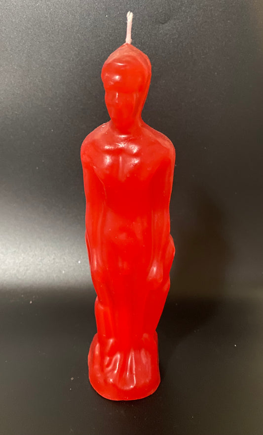 Red candle shaped like a standing figure on a black background