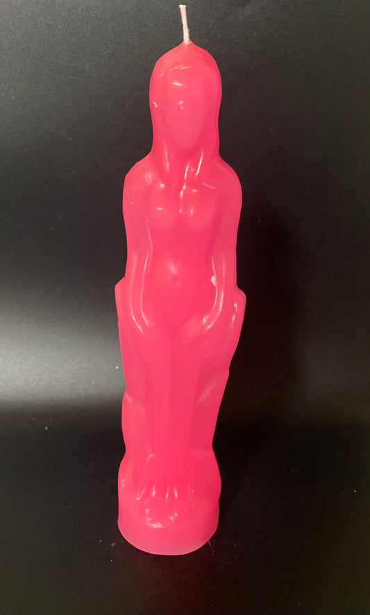 Pink candle shaped like a person on a black background