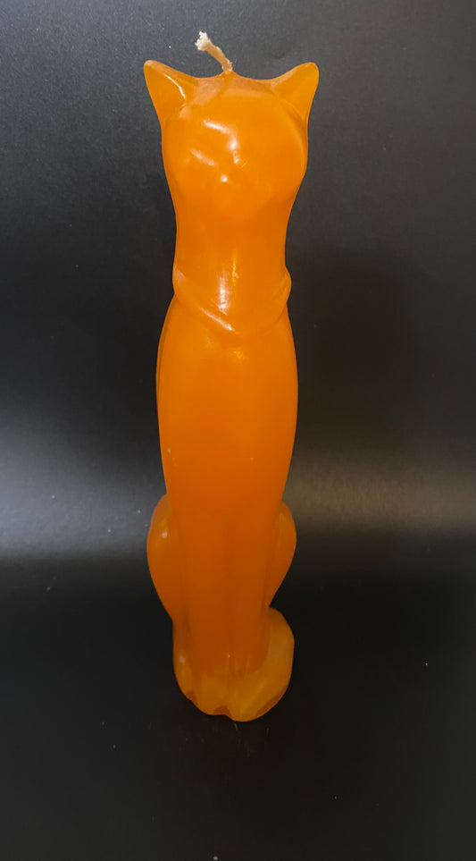 Orange cat-shaped candle on a black background