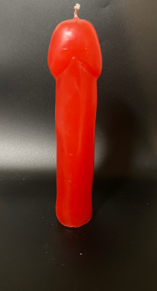Red candle shaped like a gun on a black background