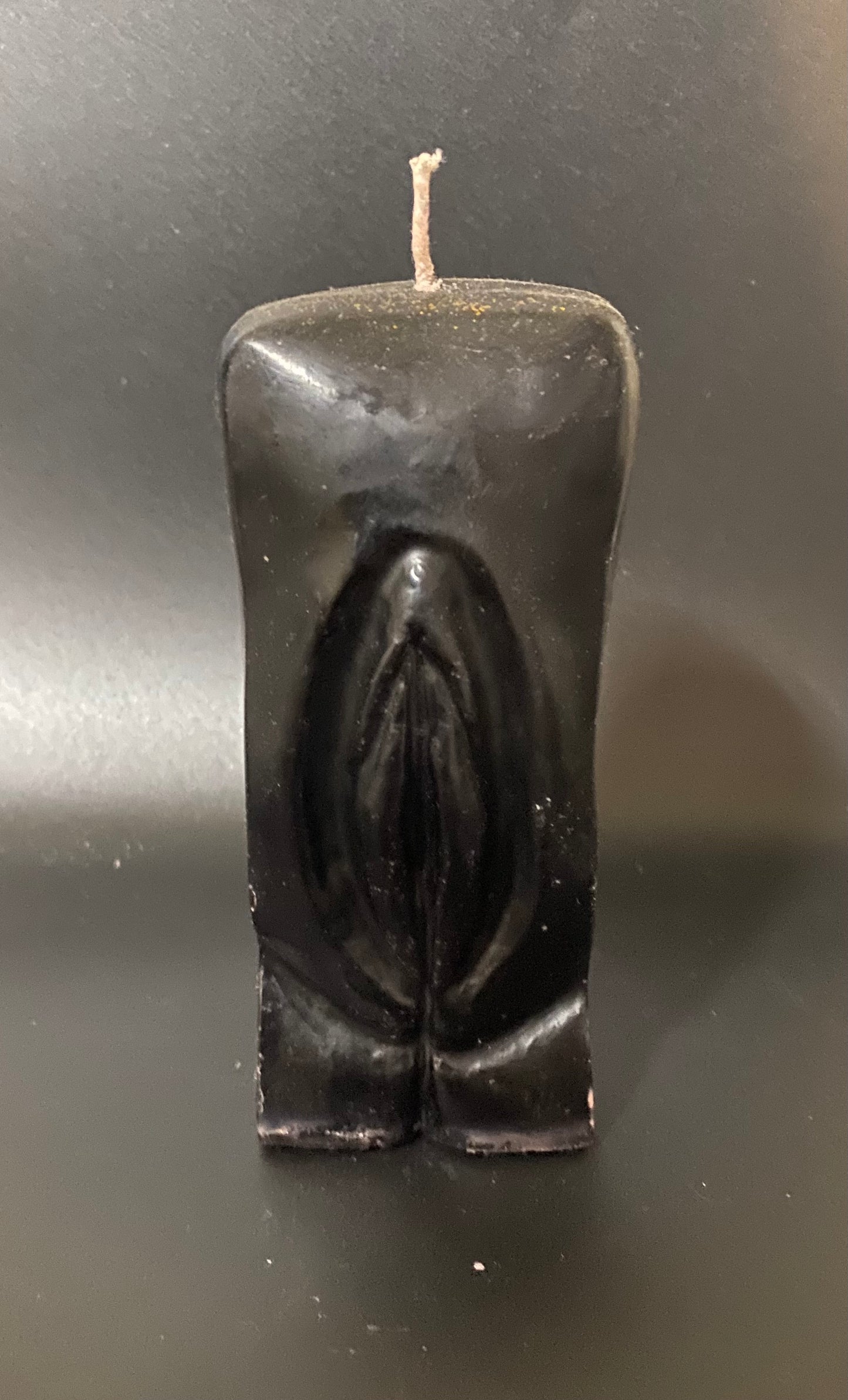 Black candle shaped like a horse on a dark background