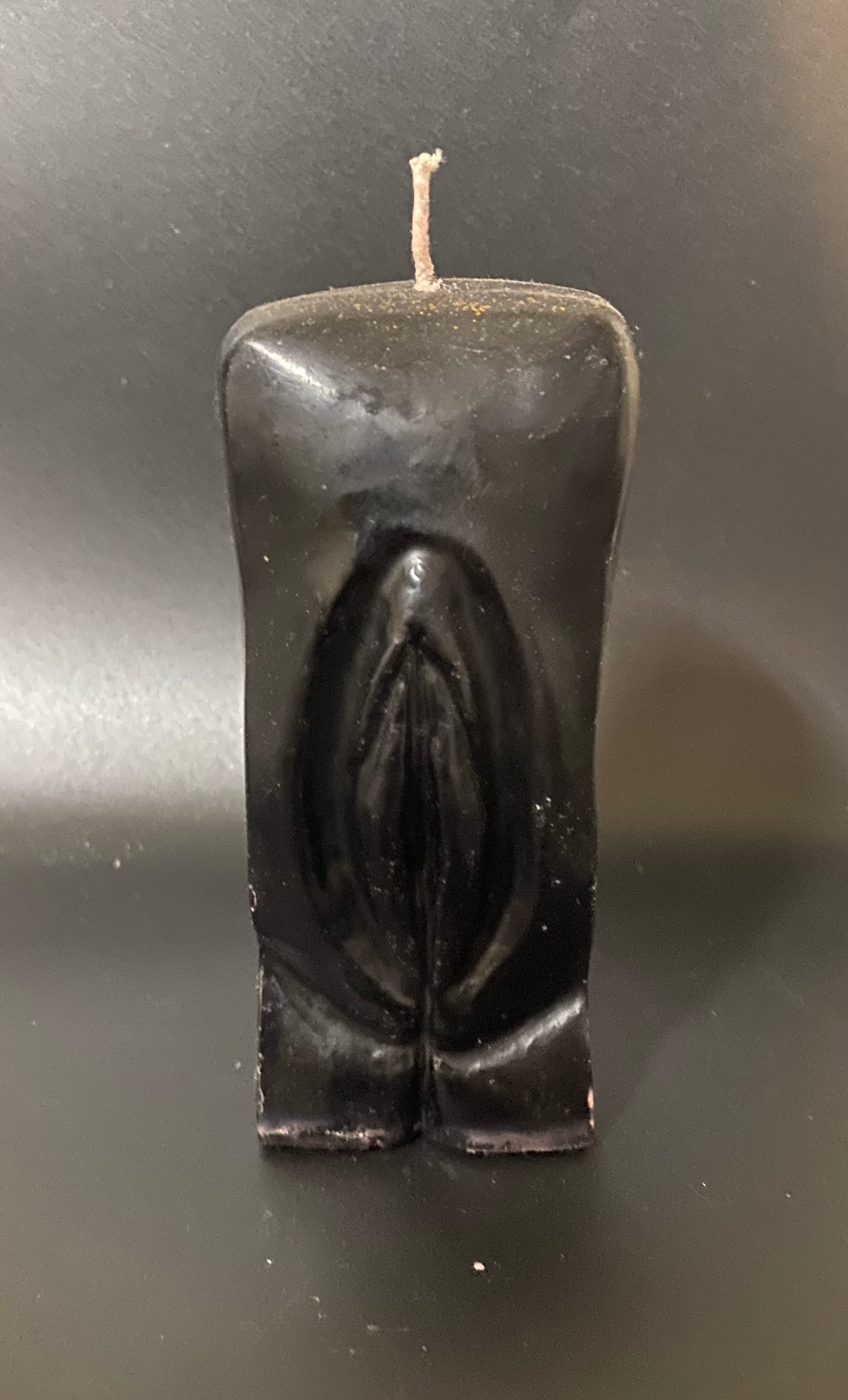 Black candle shaped like a horse on a dark background