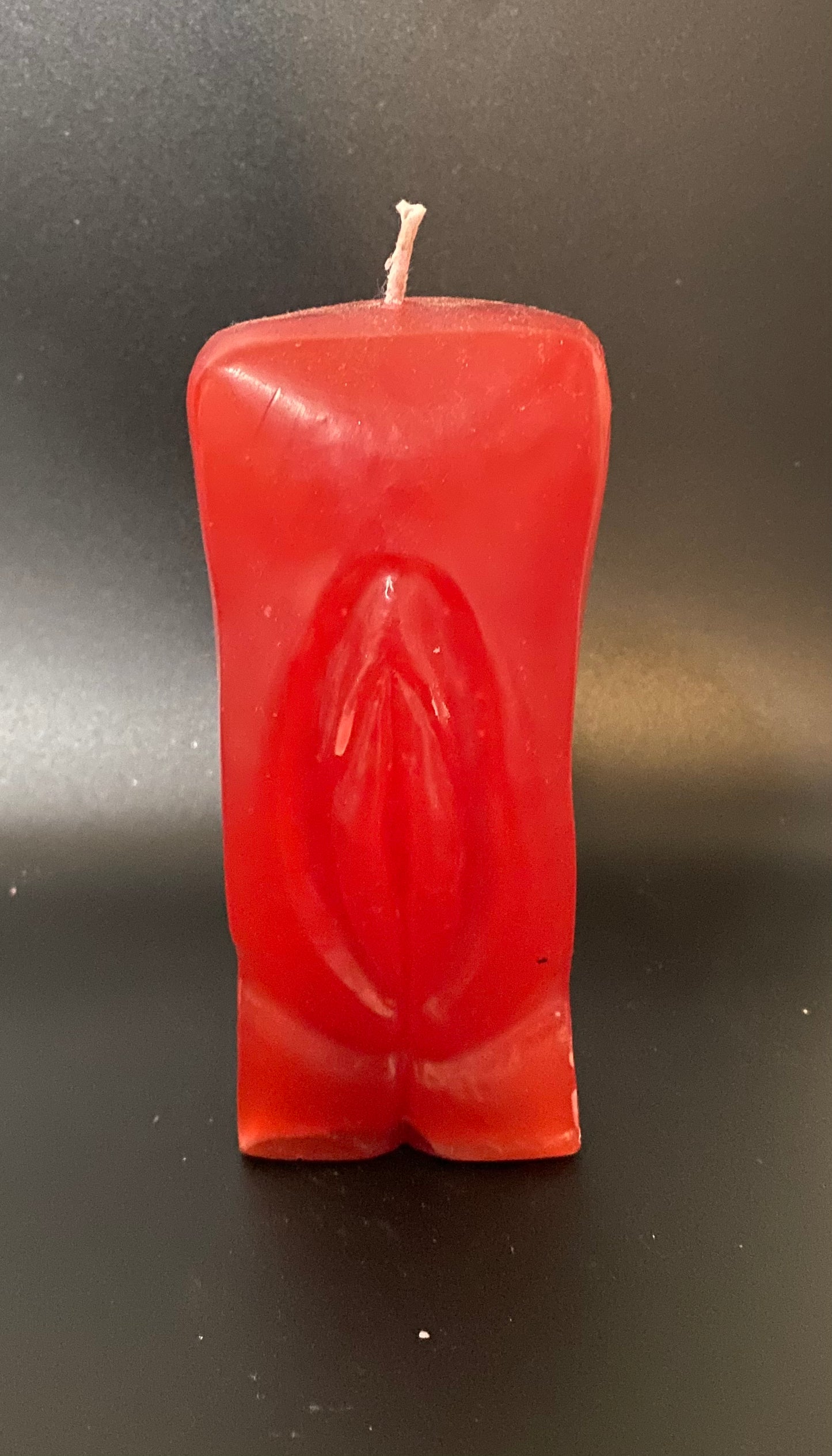 Rectangular red candle on a black background