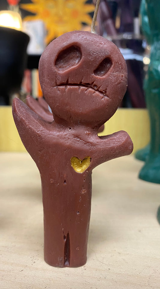 Candle figure with a face and heart detail on a neutral background