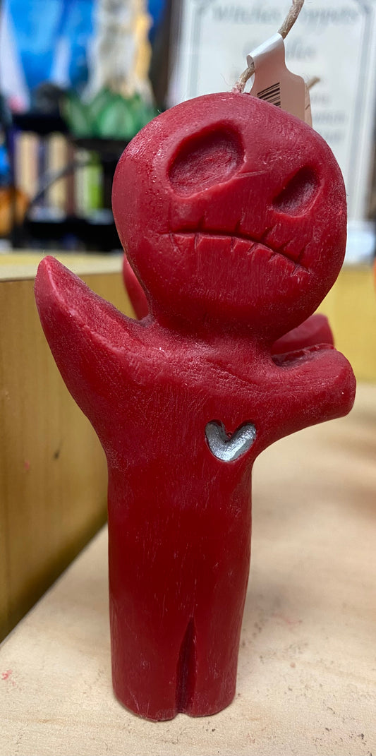 Red candle figure with a heart on a beige surface