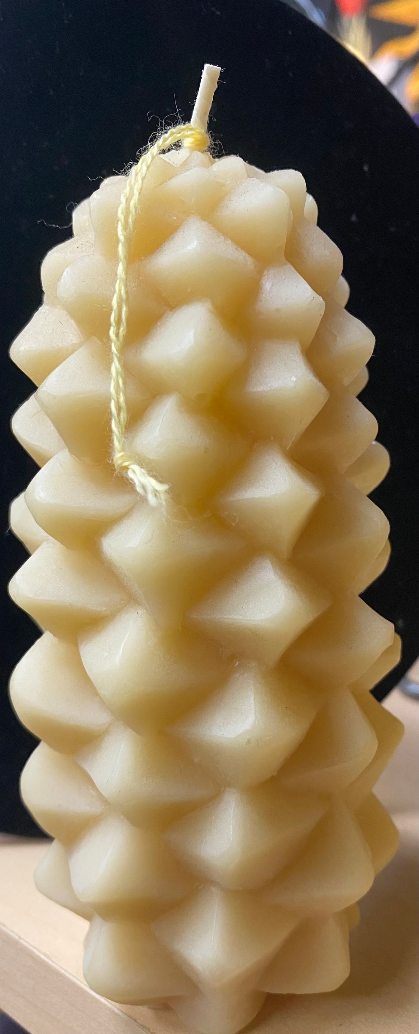 Textured white candle with a wick on a dark background