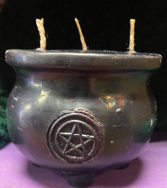 Black candle cauldron with a pentagram symbol on a dark background