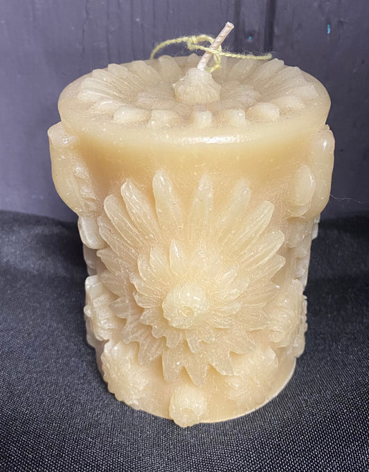 Decorative candle with floral patterns on a dark fabric background