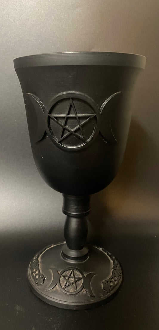 Black goblet with pentagram design on a gray background