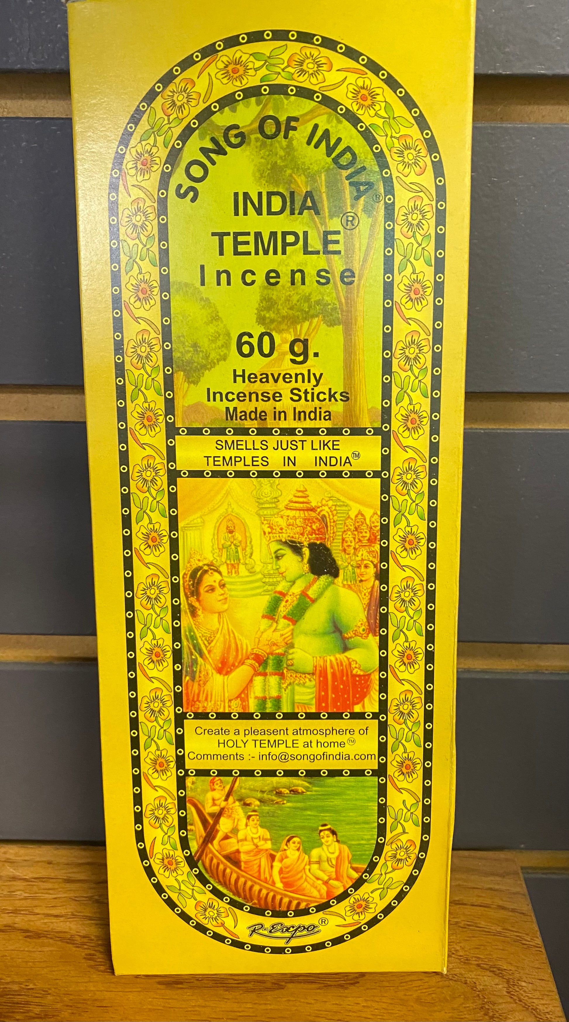 Box of India Temple Incense with yellow and green design on a wooden surface.