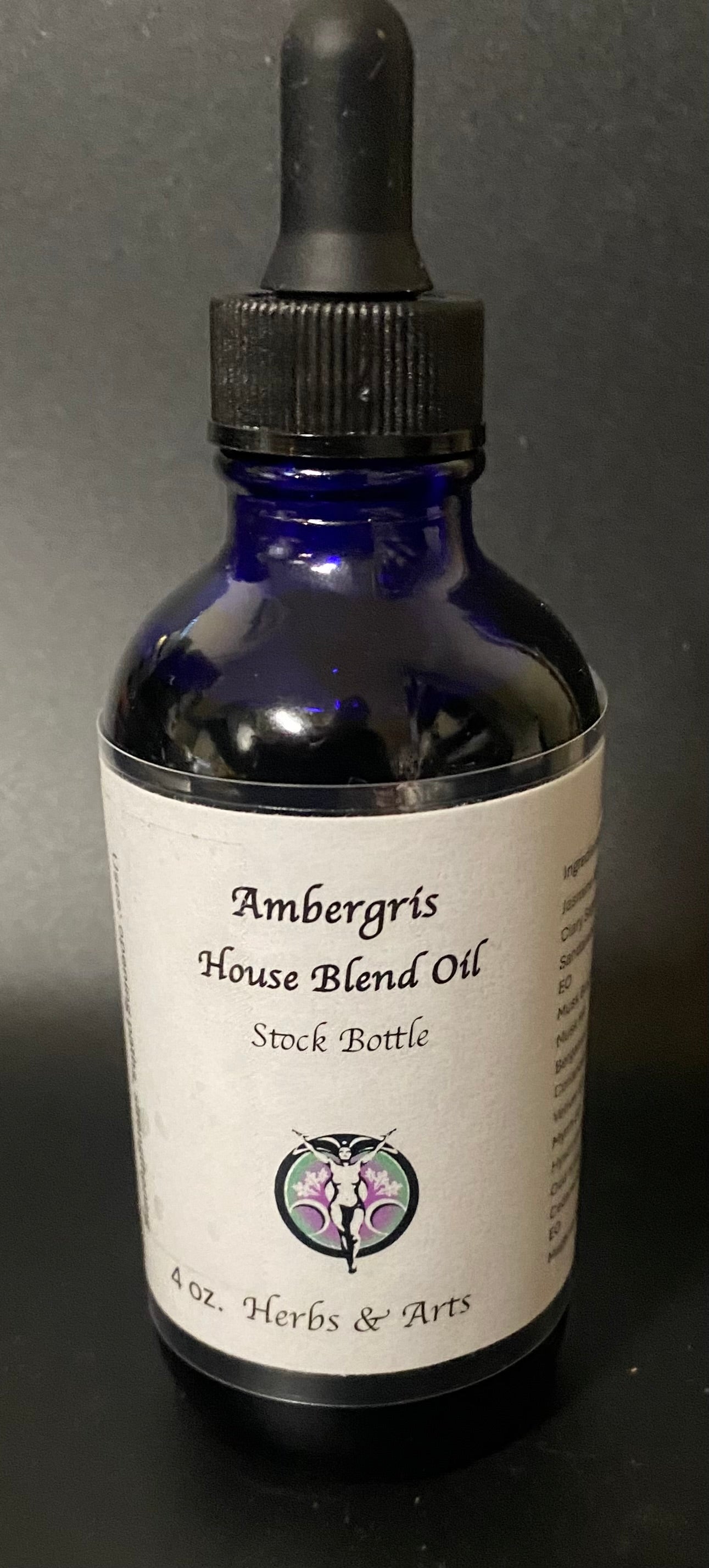 Bottle of Ambergris House Blend Oil with dropper on a dark background