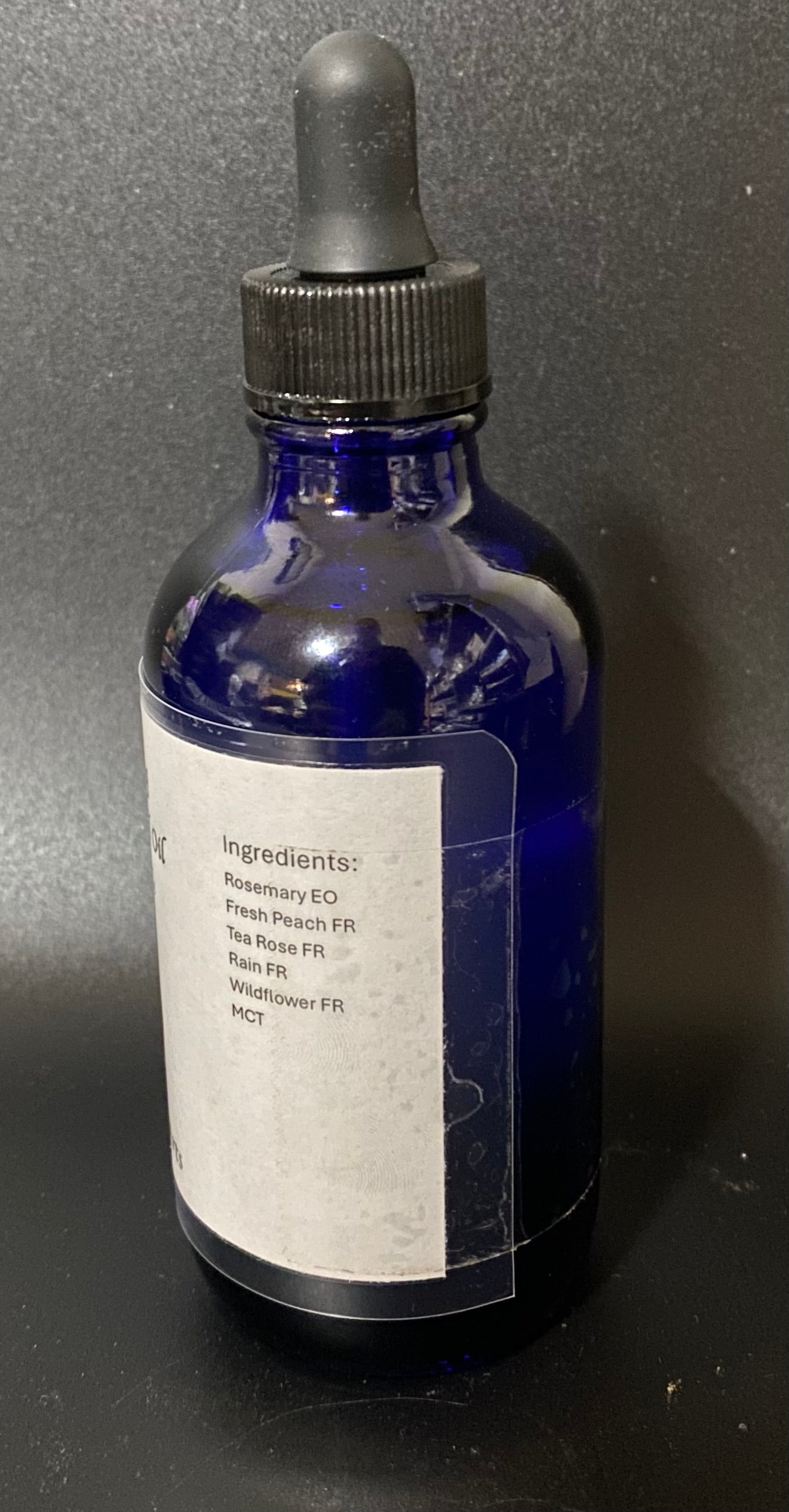 Blue glass bottle with dropper on a dark background