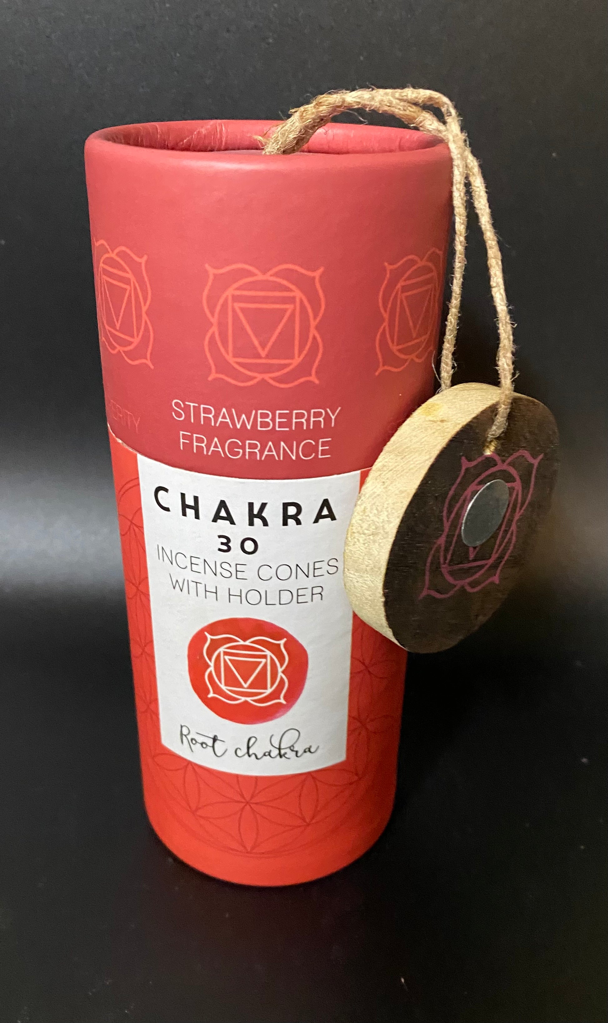 Chakra incense cone container with strawberry fragrance on a black background