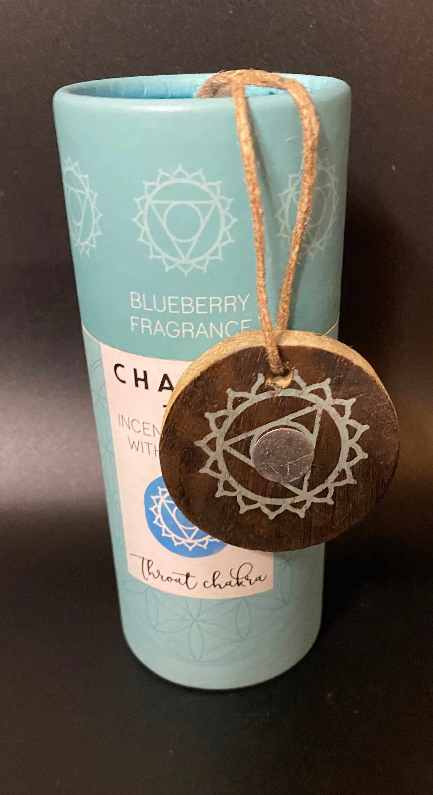 Incense stick with wooden tag labeled 'Throat Chakra' against a dark background