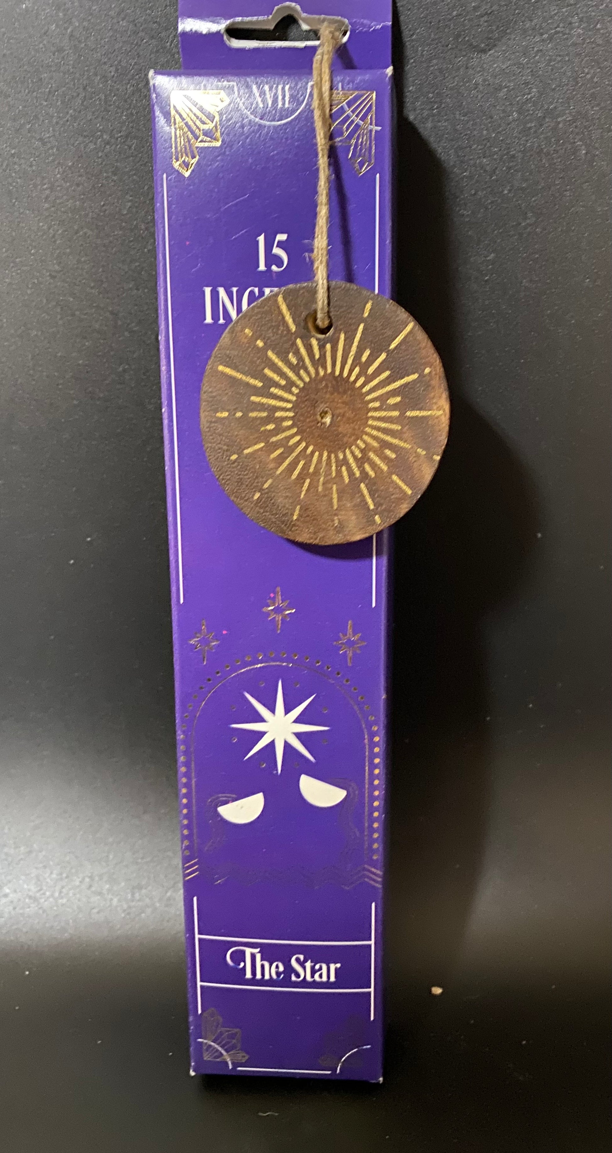 Incense stick packaging with a brass disc labeled 'The Star' on a dark background