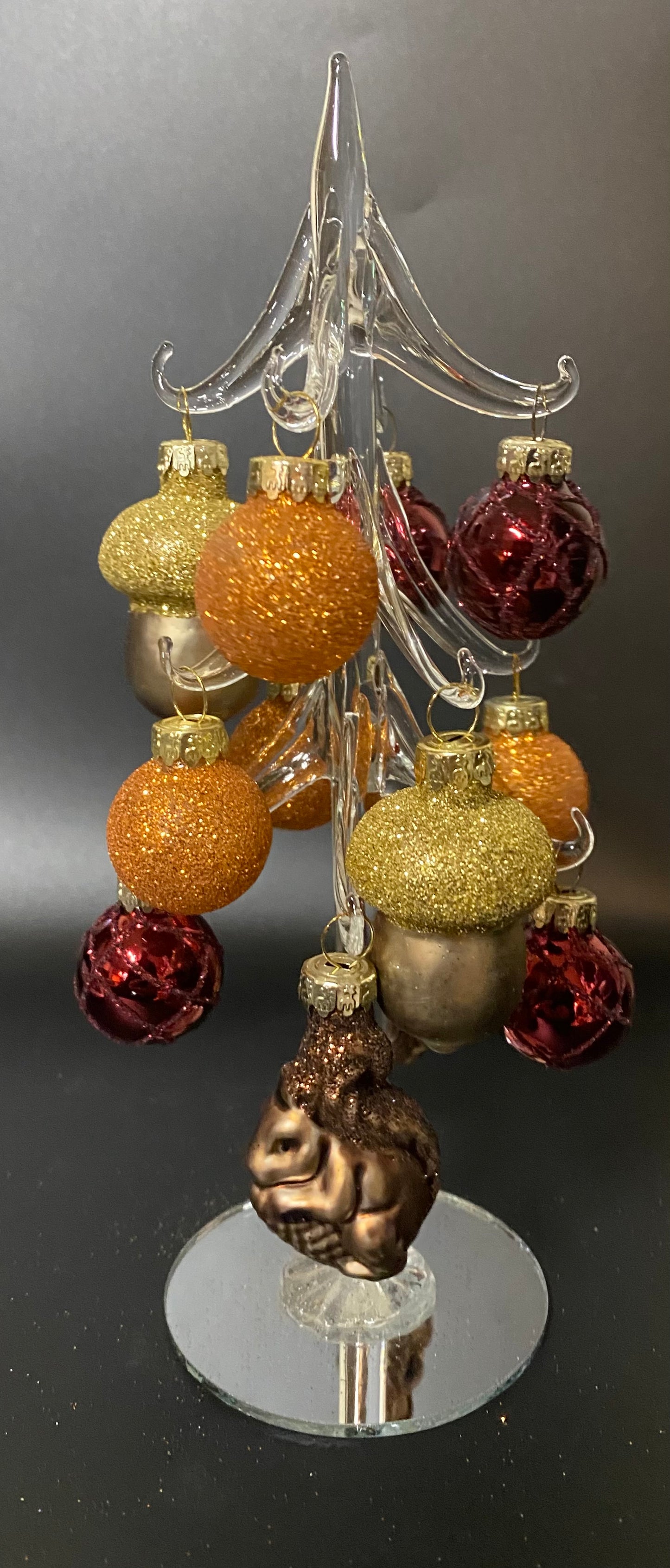 Decorative Christmas tree with colorful ornaments on a reflective surface
