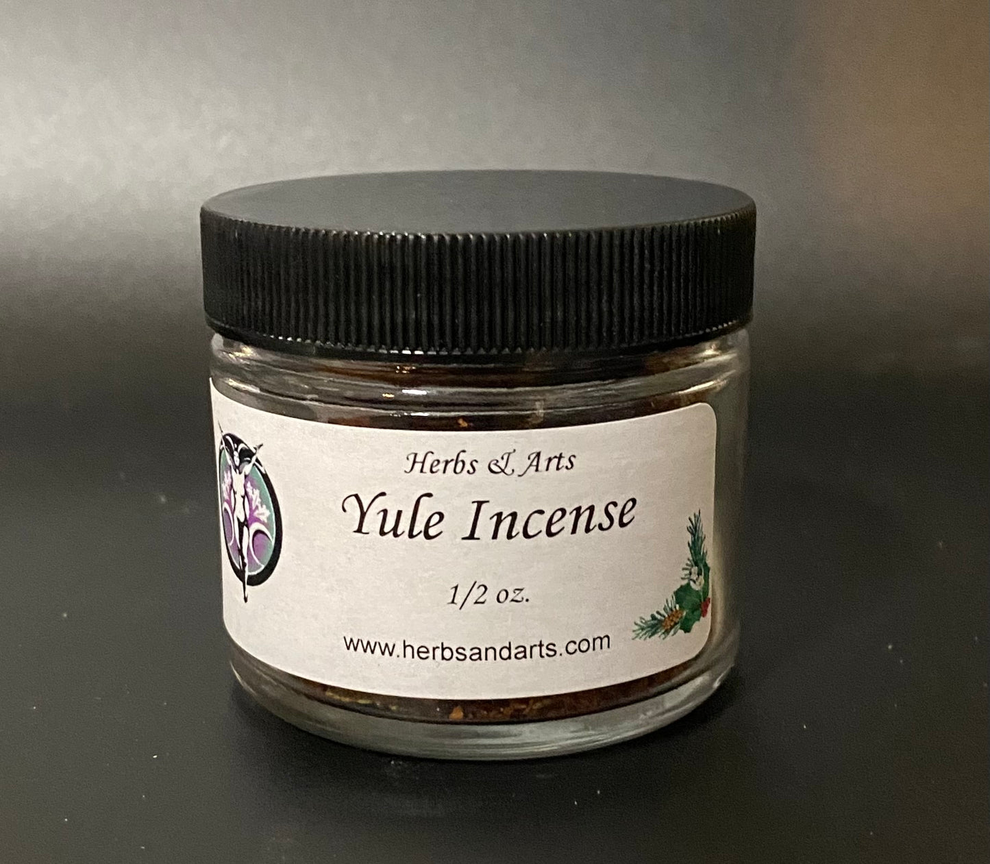 Jar of Yule Incense with a black lid on a gray background