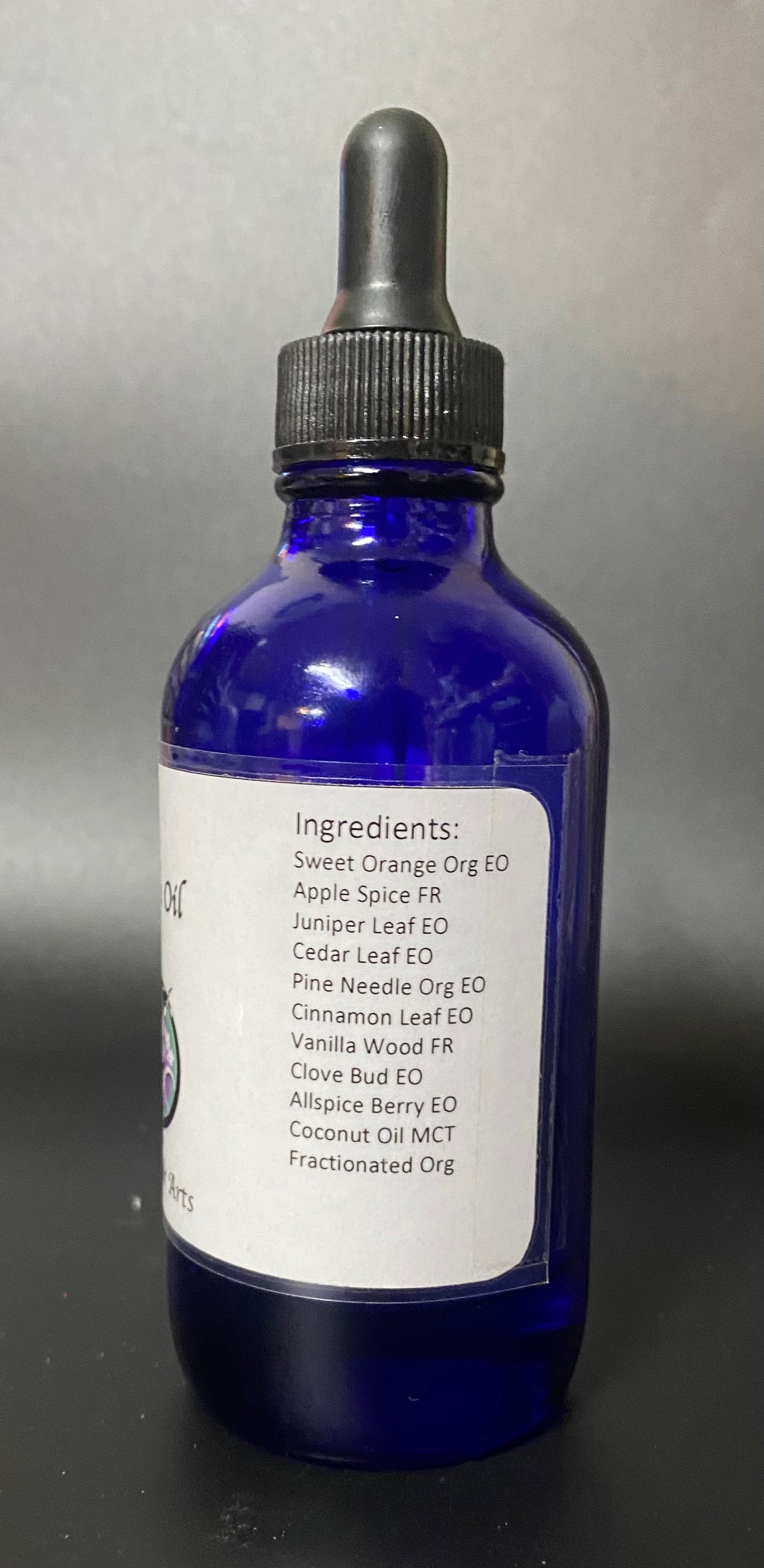 Blue glass bottle with dropper labeled 'Ingredients' on a gray background