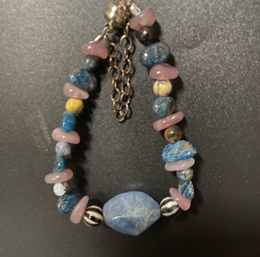 Multicolored beaded bracelet with a chain on a dark background