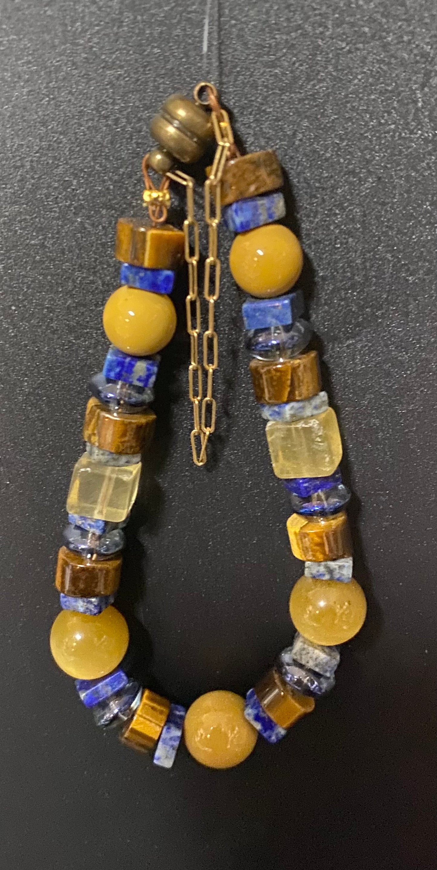 Necklace with yellow and blue beads on a dark background