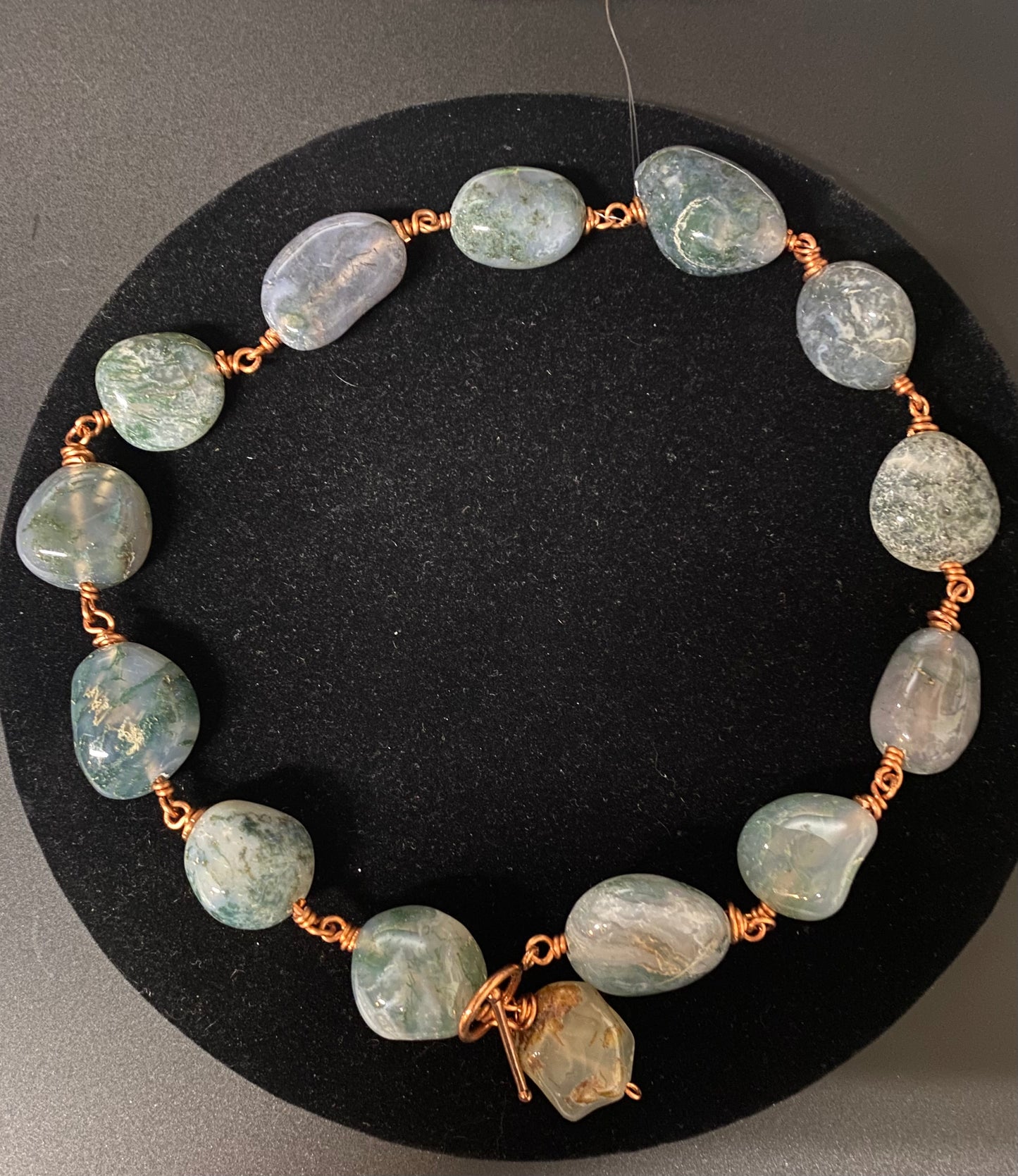 Necklace with green gemstones on a black background