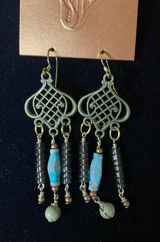 Pair of earrings with blue and green beads on a black background
