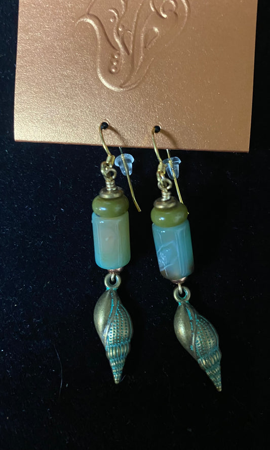 Pair of earrings with blue and green beads on a black background