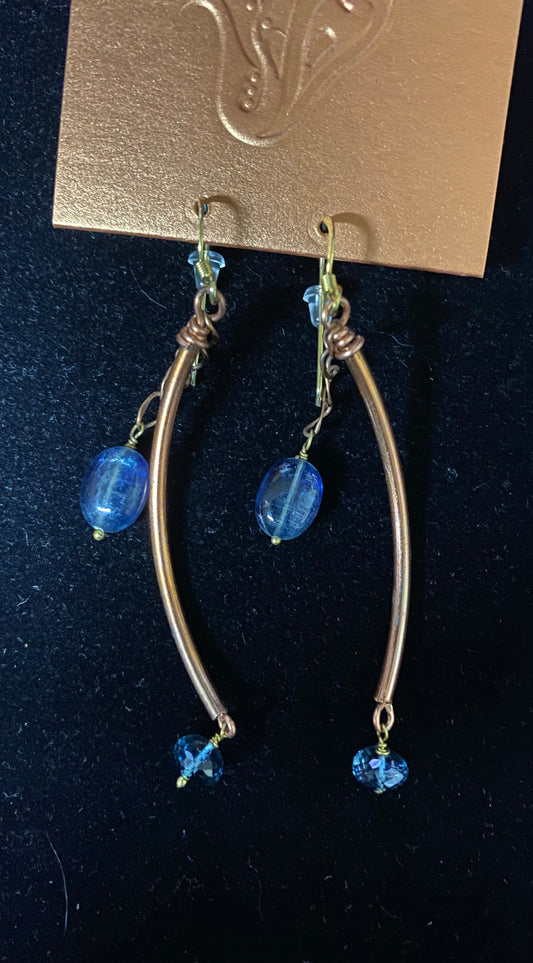 Silver hoop earrings with blue beads on a dark background