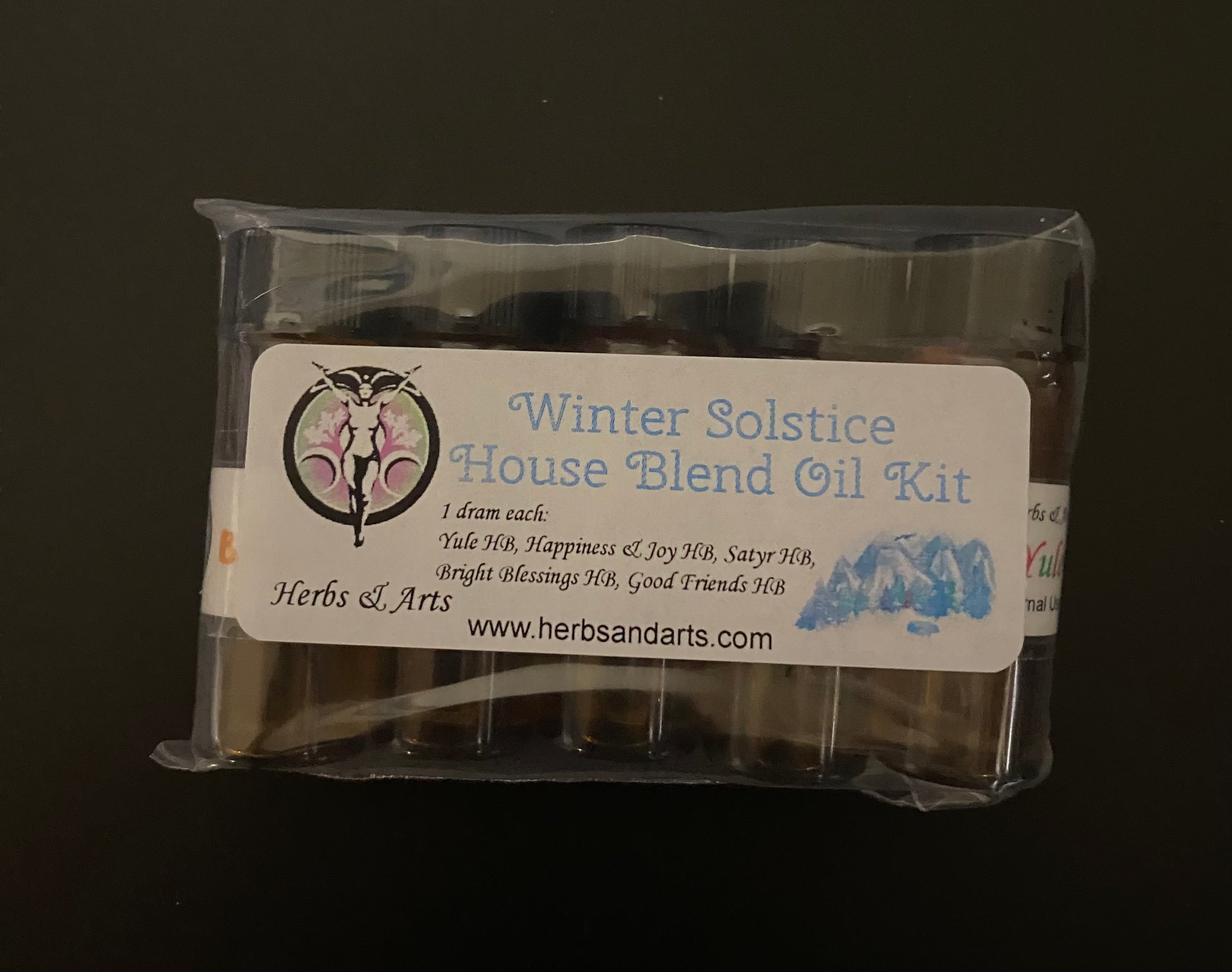 Packaged oil kit labeled 'Winter Solstice House Blend Oil Kit' with branding on a dark background