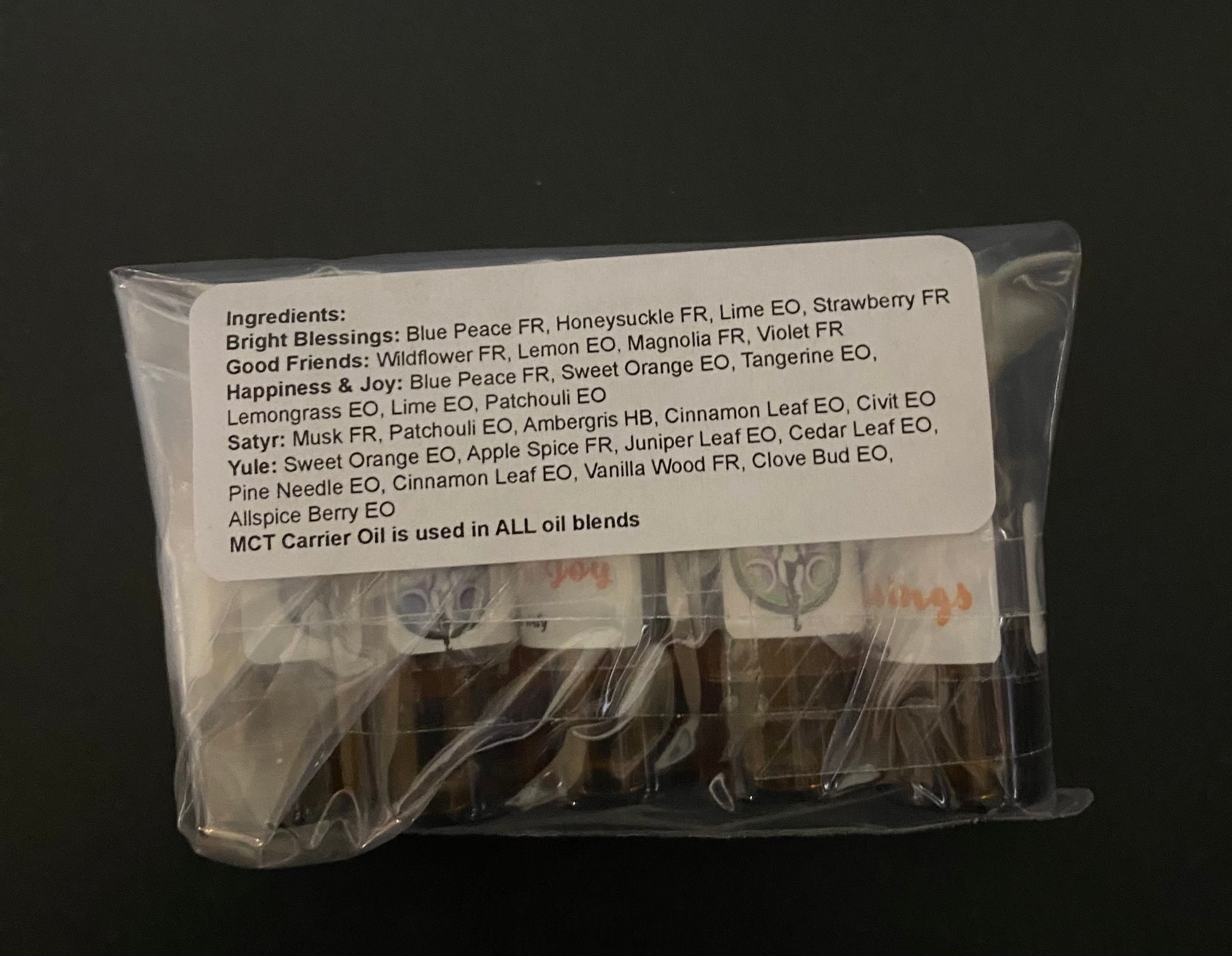 Packaged essential oil bottles with a label on a black background