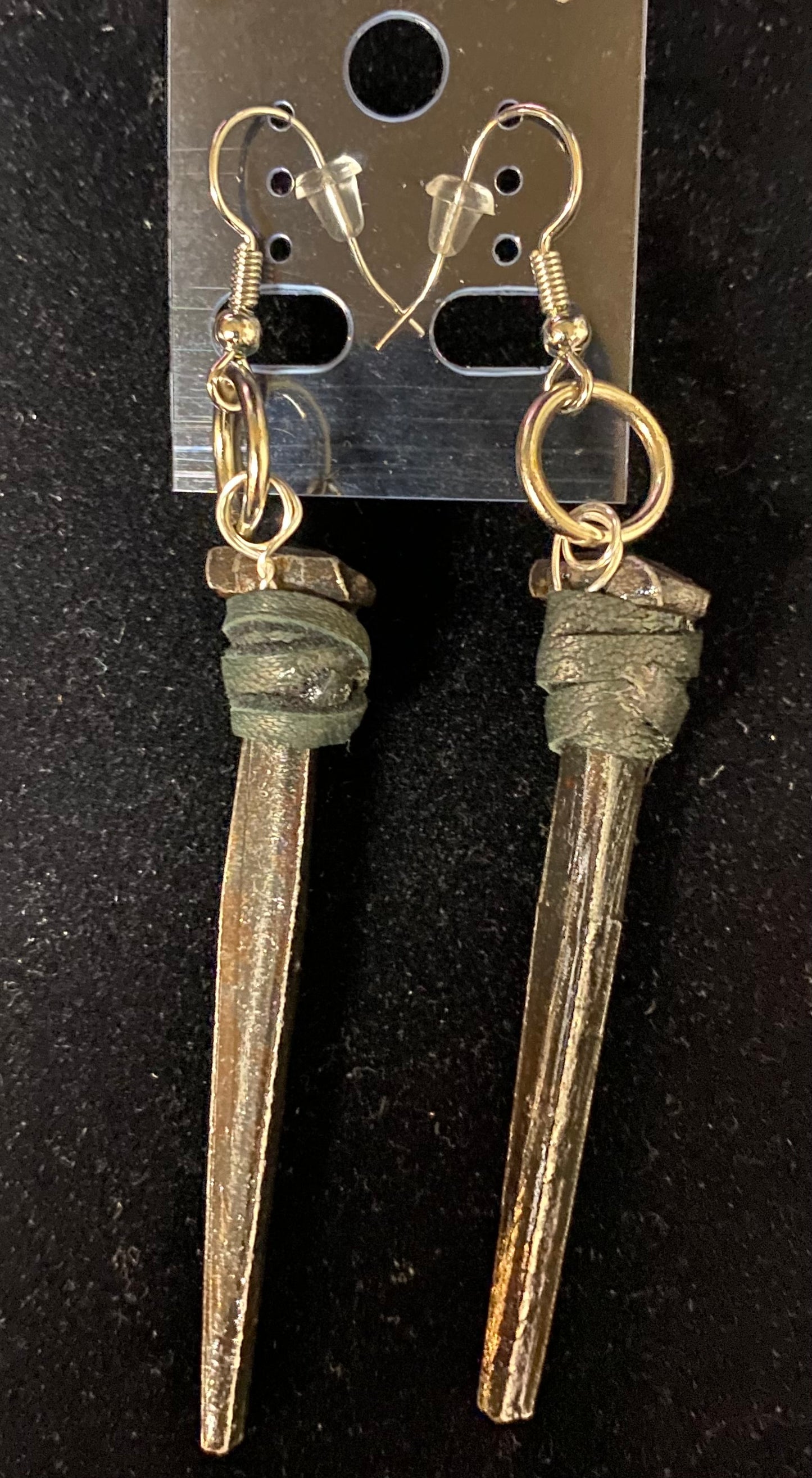 Iron nail earrings on a black background