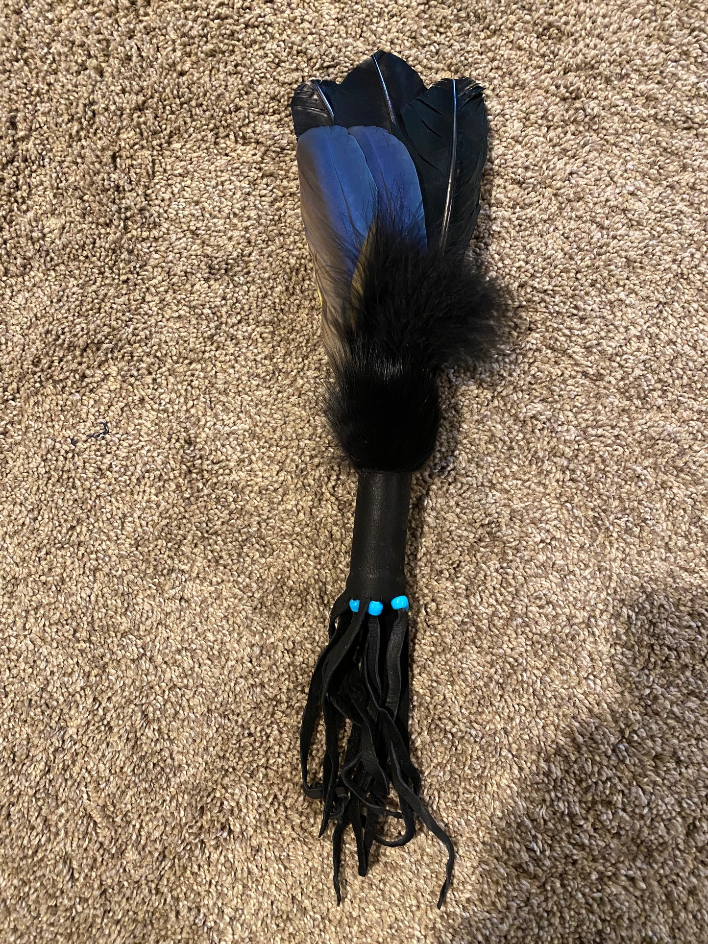 Feathered object on a brown carpet