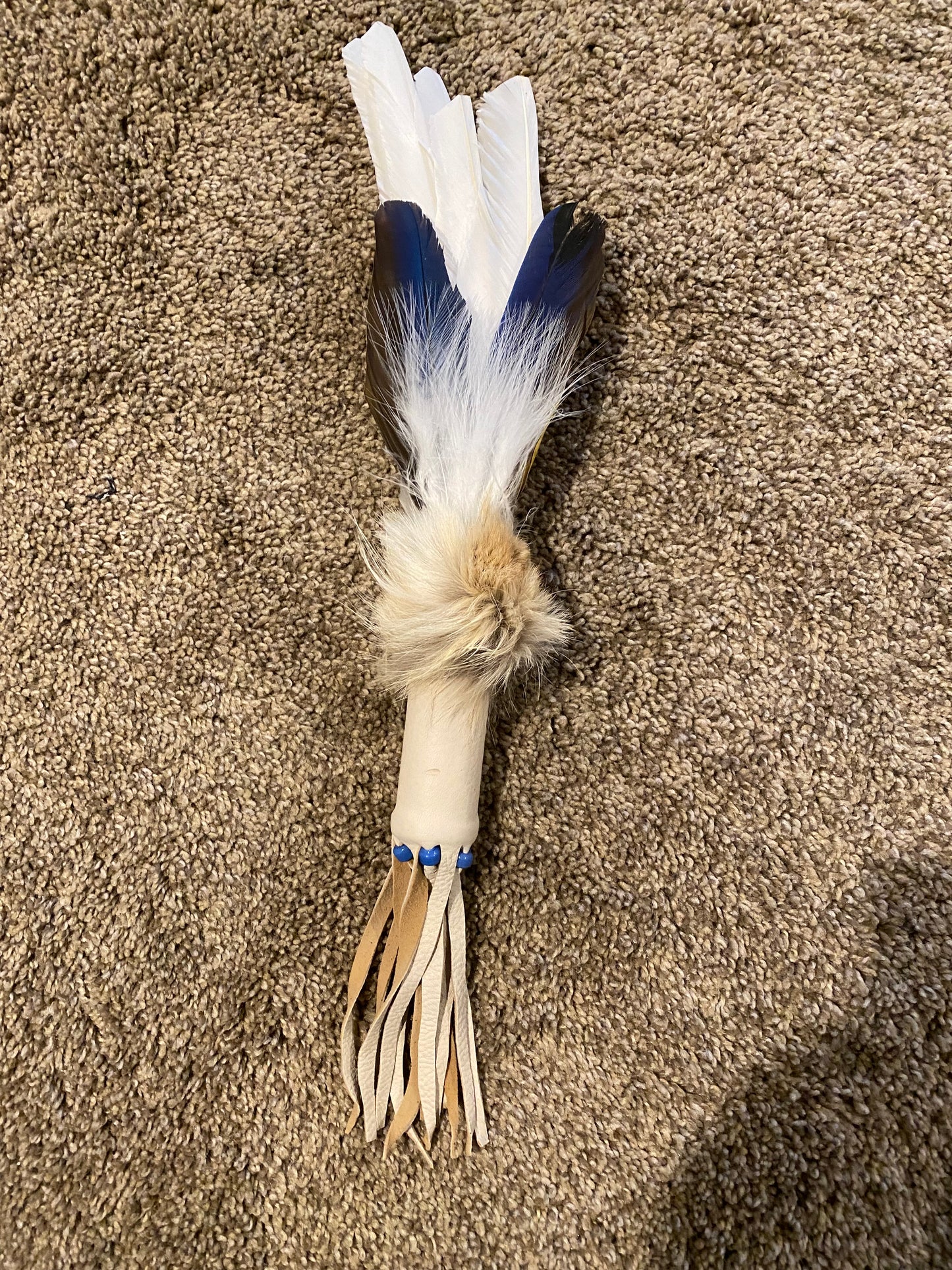 Feathered object on a brown carpet