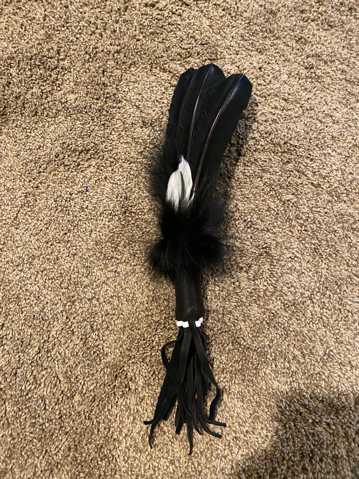 Feathered object on a brown carpet