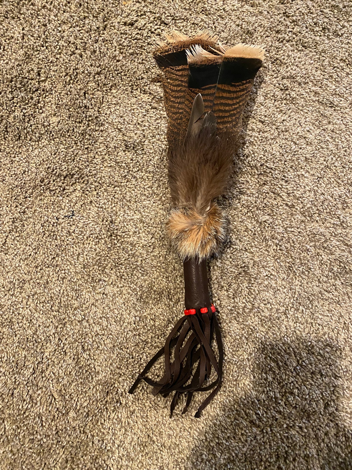 Feathered object on a brown carpet