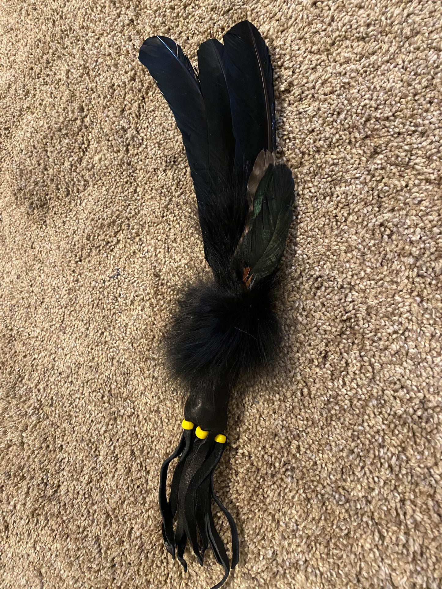 Feathered object on a brown carpet