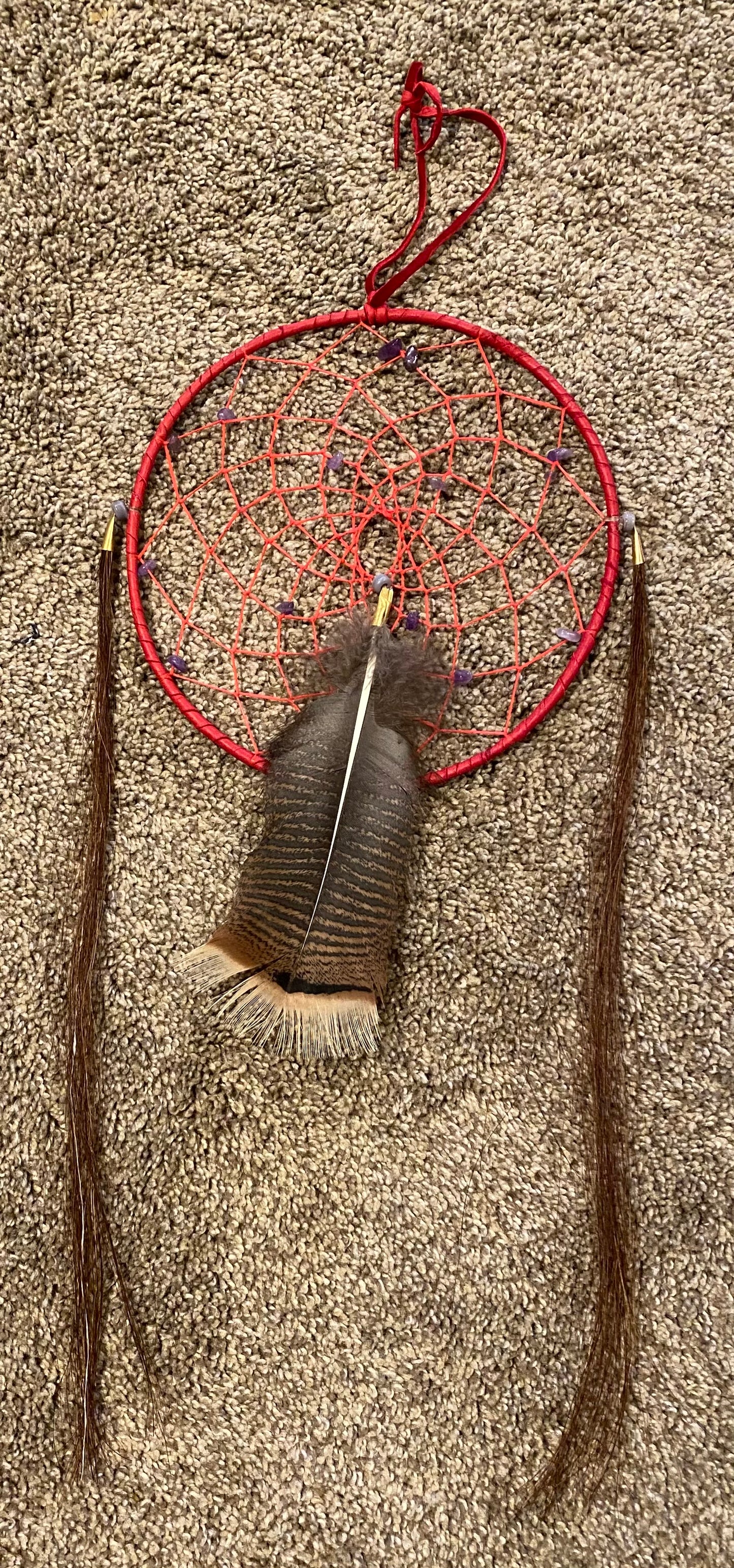 Dreamcatcher with feathers on a textured surface