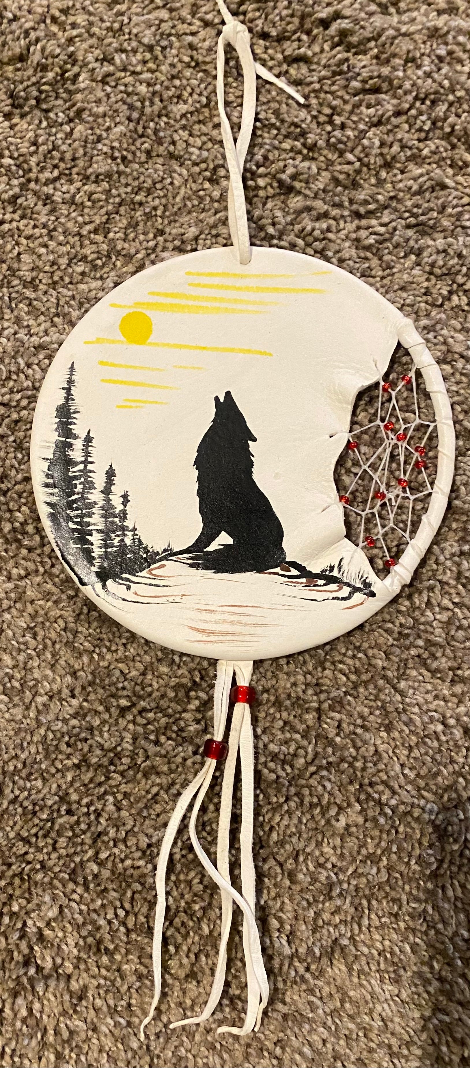 Decorative wall hanging with a wolf silhouette, moon, and dreamcatcher design.