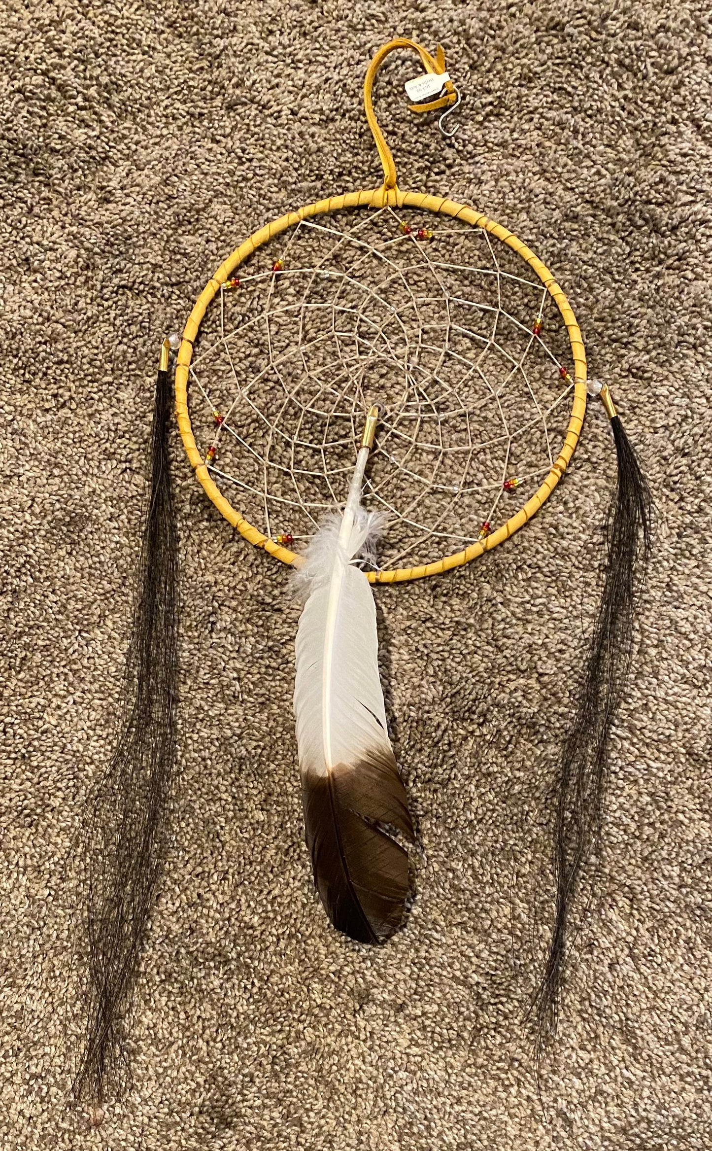 Dreamcatcher with a feather on a textured surface