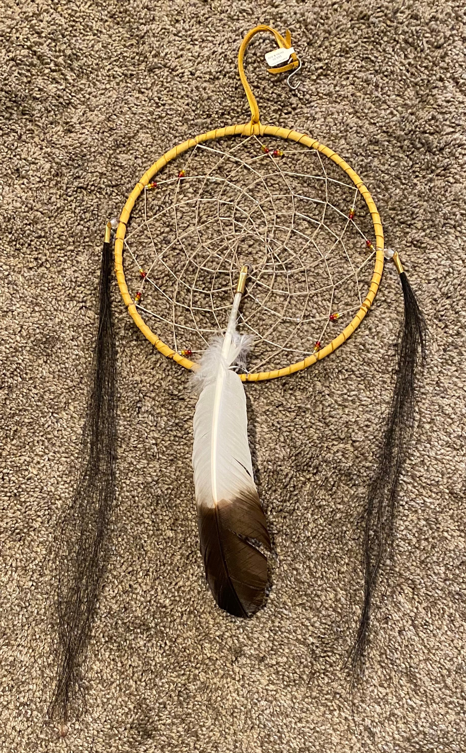 Dreamcatcher with a feather on a textured surface