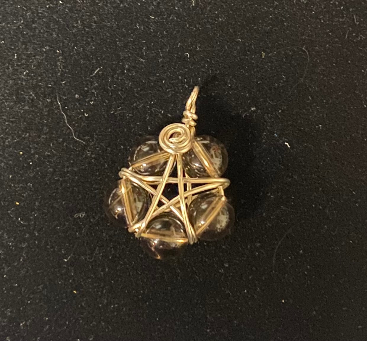 Silver pentacle pendant with smoky quartz stones on a black background