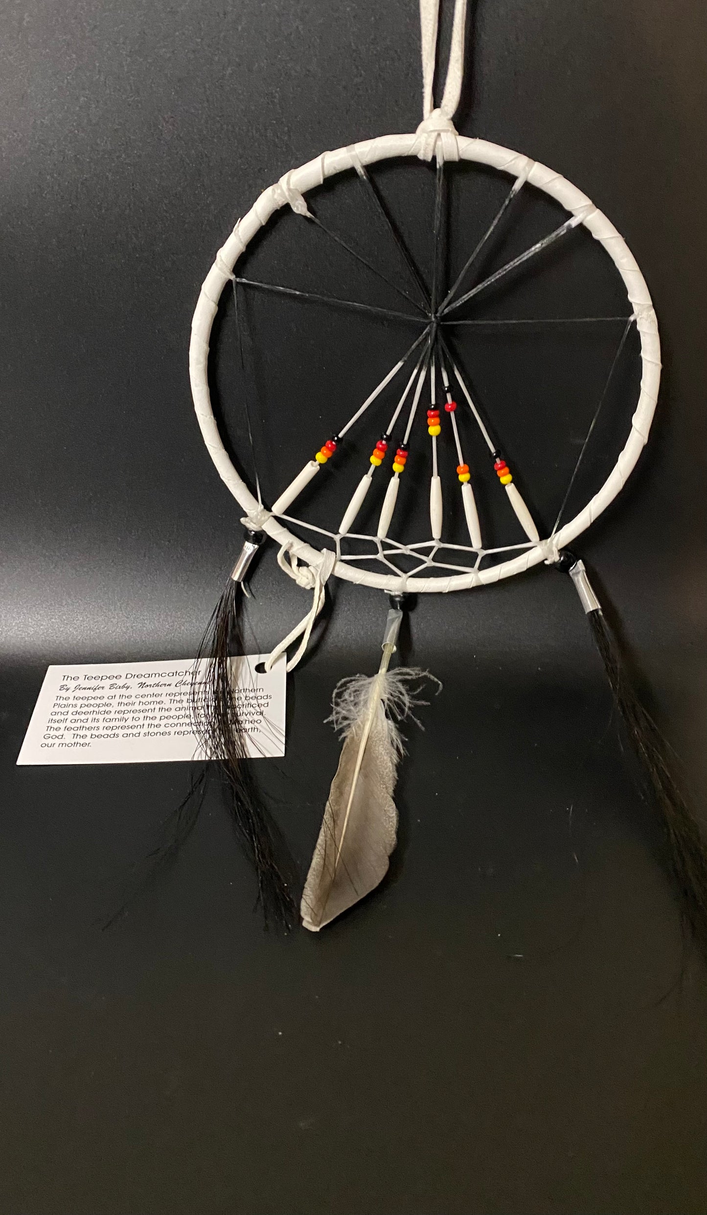 Dreamcatcher with feathers and beads on a black background