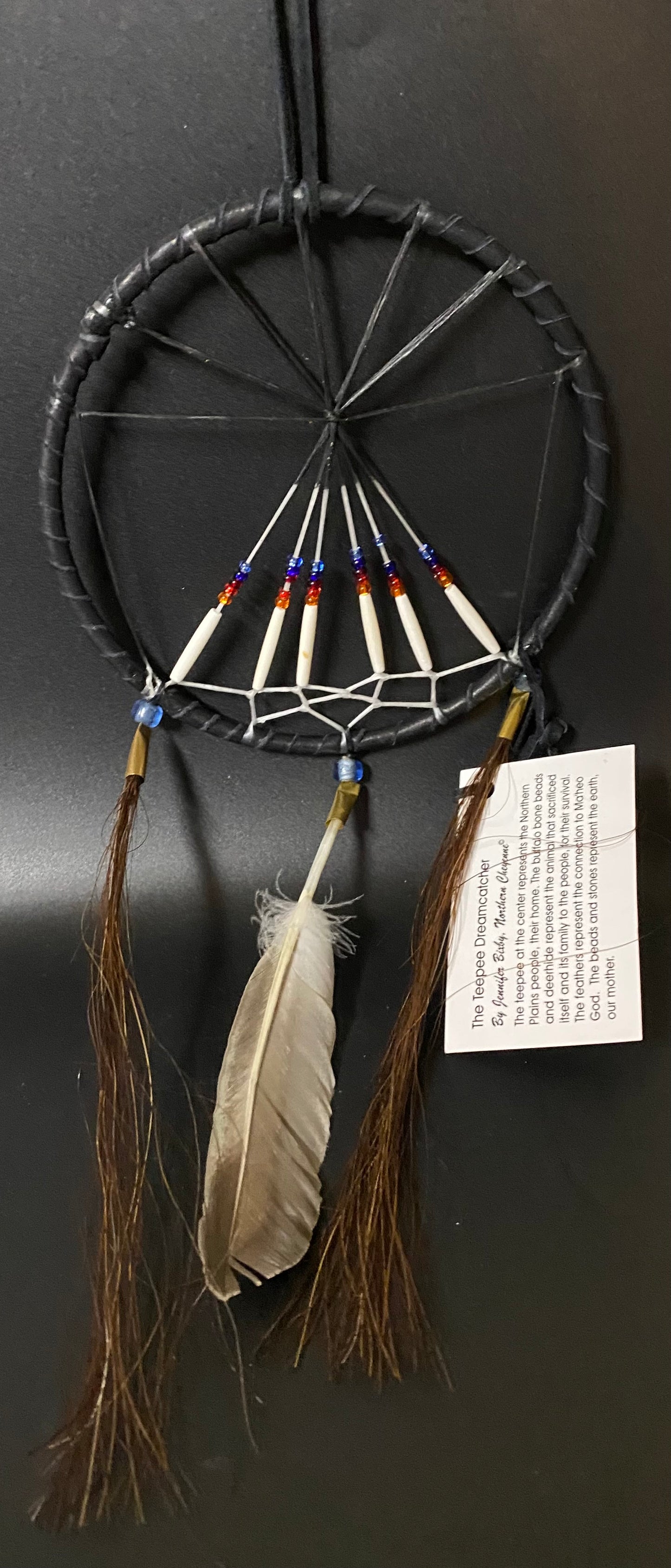 Dreamcatcher with feathers and beads on a black background